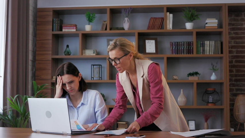 Angry female boss screaming at scared office worker. Demanding manager leader is annoyed at laziness and mistakes in work of employee. Authoritarian leadership, abuse of power, malfeasance in office. Royalty-Free Stock Footage #1092066453