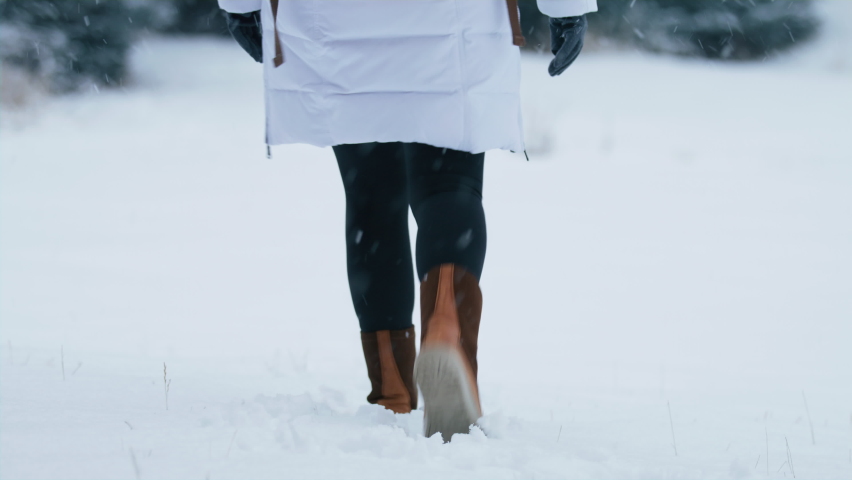 Slow motion woman feet walking in winter boots by fresh white snow on snowy winter day leaving footprints. Female tourist on winter vacation in Aspen Colorado USA. Woman in winter coat with backpack Royalty-Free Stock Footage #1092068105