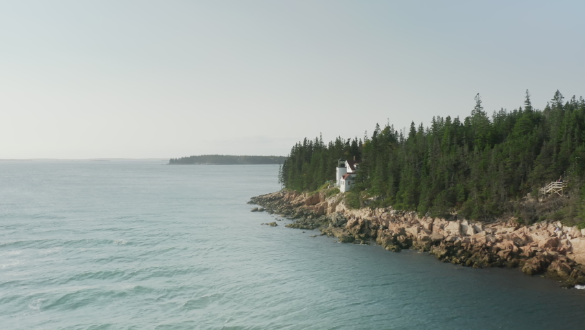 Scenic rugged coastline of Mount Desert Island in Acadia National Park. Aerial Bass Harbor Head Lighthouse landmark at Bass Harbor, Maine. Travelers exploring dramatic Acadia rocky coastline, USA trip