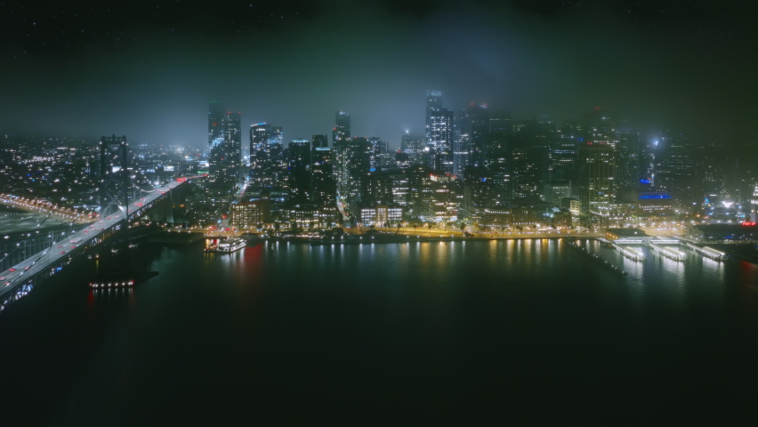 Modern architecture waterfront skyscraper glass buildings of San Francisco cityscape background. USA California, stars in night sky. Establishing aerial view foggy night San Francisco downtown skyline