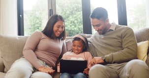 Young happy family using a digital tablet while relaxing on a sofa together at home. Parents streaming a funny video or movie with their daughter on a sofa. Little girl bonding with her mom and dad