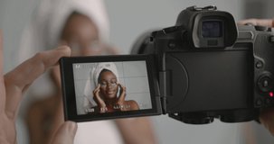 Video camera recording black girl applying eye patches