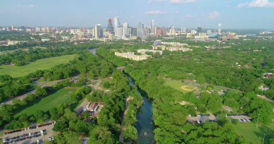 A view of Zikler Park and Barton Springs in downtown Austin, Texas. Flying over Barton Creek towards the city