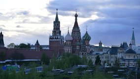 Time lapse video of Moscow Kremlin and Saint Basil's Cathedral in Moscow city at sunset. Clouds on the sky. Large group of unidentified people walks in Zaryadye park. Travel in Russia theme.