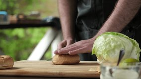 Cooking, chef bread on a burger, on the table. Video shooting 4k