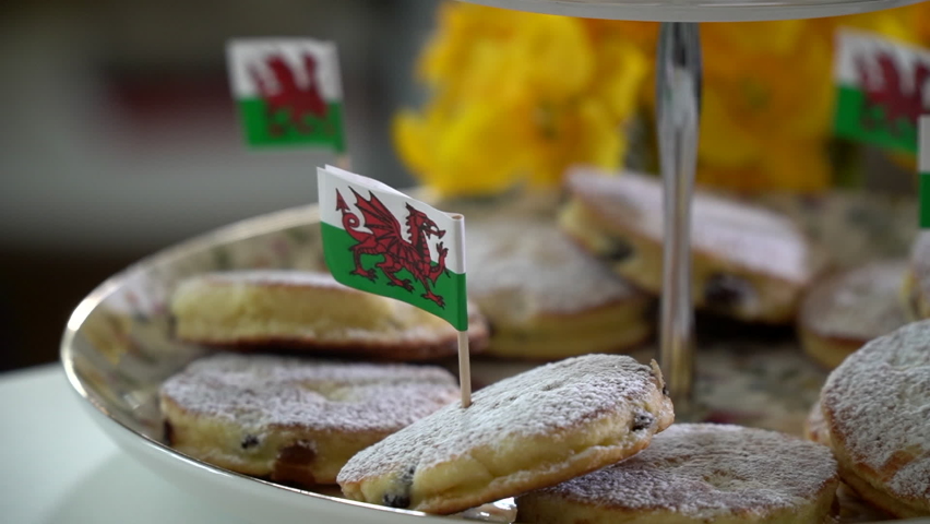 Closeup of traditional Welsh cakes with Welsh flag in panning shot. Royalty-Free Stock Footage #1092079895