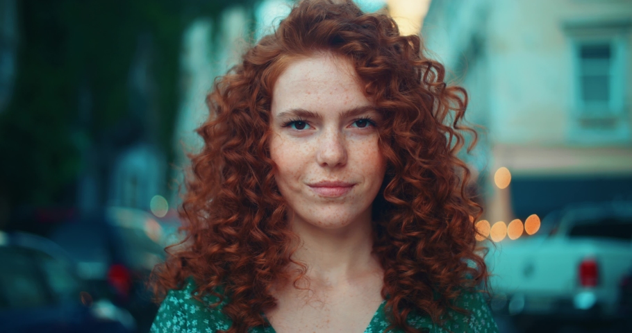 Portrait face young sunshine young woman with red hair look at camera smile stand in the city streets. Beautiful town at sunlight. Feel happy. Slow motion Royalty-Free Stock Footage #1092082033