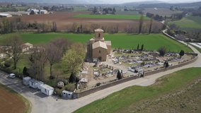 Church and cemetery at sunrise, Chabrillan, Provence, France - Orbital Aerial Drone Video
