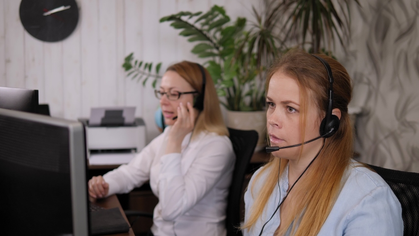 Portrait of an angry annoyed woman in a tech support office, she is talking on a headset with a harmful disgruntled customer. Problems while working in a call center.