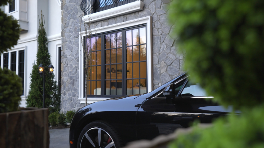 A black luxury car parked in the driveway of a magnificent private estate. This modern take of a timeless design gave birth to a world-class home in the suburbs of Vancouver, BC Royalty-Free Stock Footage #1092094075