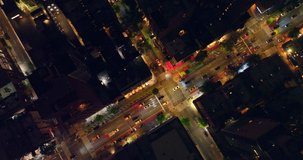 Diverse lights on the streets of New York at night. Busy traffic flow over the roads of metropolis from bird's eye view.