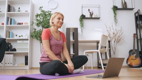 Female fitness trainer holding online lesson, training client via video call