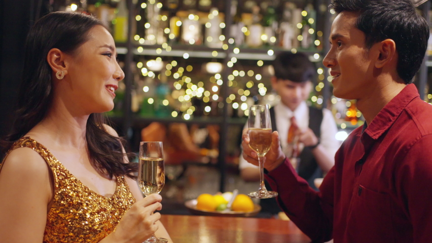 4K Asian man and woman flirting each other while hangout nightlife party at luxury restaurant bar. Attractive female have romantic dating with boyfriend celebrating holiday event together at nightclub Royalty-Free Stock Footage #1092104103