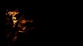 Fire flame isolated black isolated background Beautiful orange. Flame border . Sparks from campfire over dark night background. Christmas background, Slow motion. Bonfire is burning, vertical video