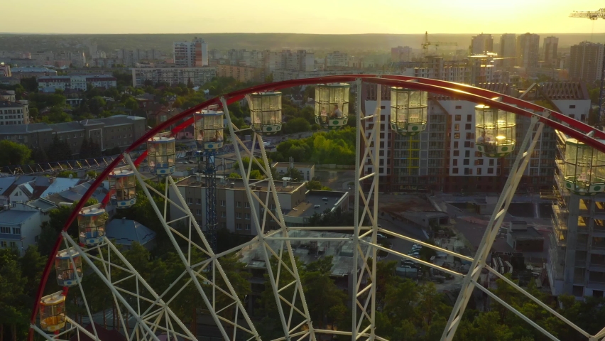 Carousel Wheel against the background of the city: Kharkiv 2021. Attraction big ferris wheel in Kharkiv. Gorky Park, Kharkiv Ukraine. Ferris wheel against the backdrop of the cityscape. Royalty-Free Stock Footage #1092106763