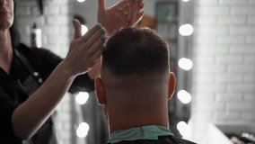 Barber using a gel for hair styling men while working in the modern barbershop. Hair cosmetic. Hair styling. Beauty salon