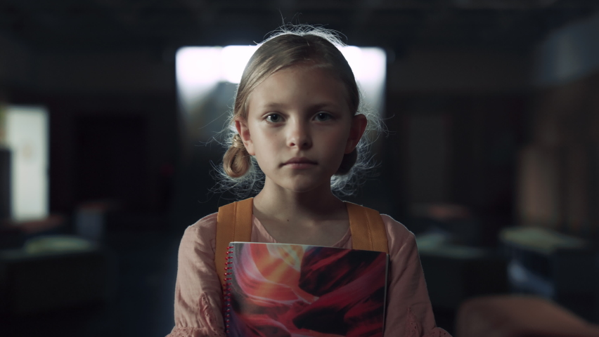 Upset preteen girl holding notebook standing dark school hall close up. Dejected little schoolgirl posing with blond pigtails feeling unhappy. Tensed child frightened by bullies. Teen crisis concept. | Shutterstock HD Video #1092108209