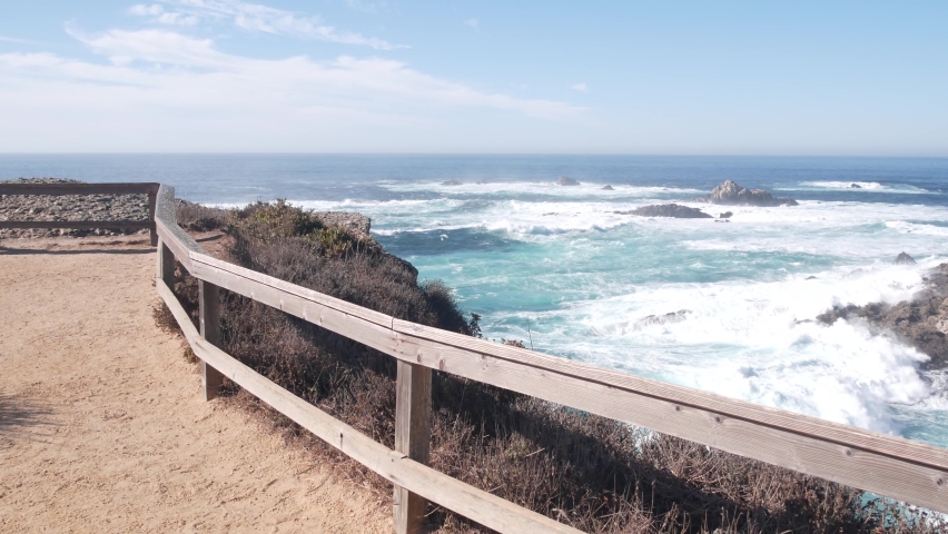 Rocky craggy ocean beach. Big waves crashing on cliff, water splashing, sea foam. Power of nature near Big Sur, 17-mile drive. Point Lobos seascape, Monterey, California coast, USA. Trail for hiking.