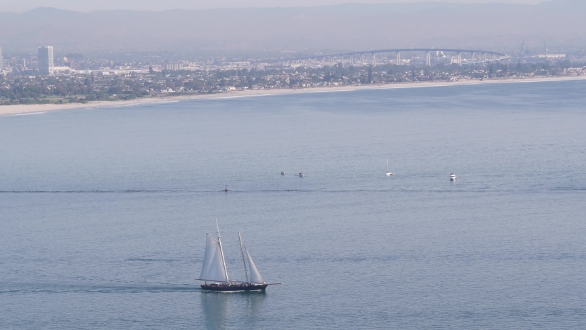 San Diego city skyline, cityscape of downtown with highrise skyscrapers, California coast, USA. View of Coronado island from above, Point Loma vista viewpoint. Frigate sail-powered ship, windjammer.