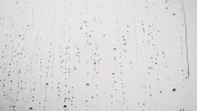 Rainy realistic footage, raindrops flowing on the window, summer or autumn season background, abstract textured wallpaper, 4k live video.