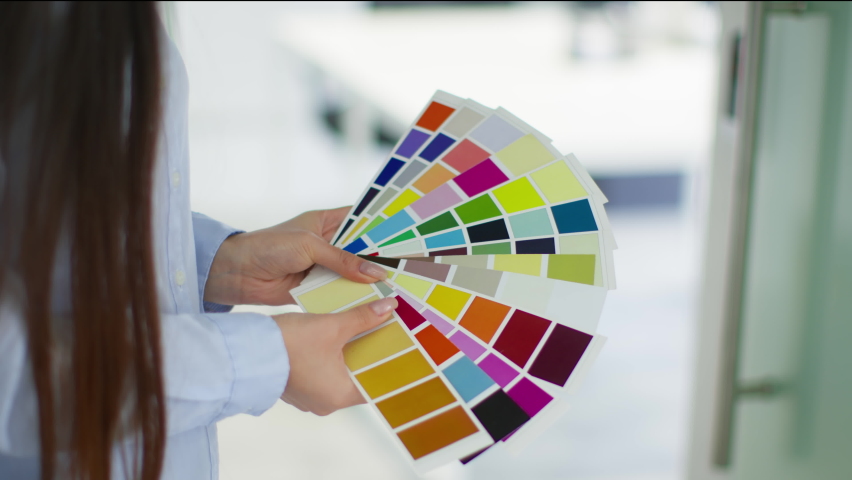 Design details. Close up shot of unrecognizable lady interior of fashion designer studying color swatches at office, slow motion