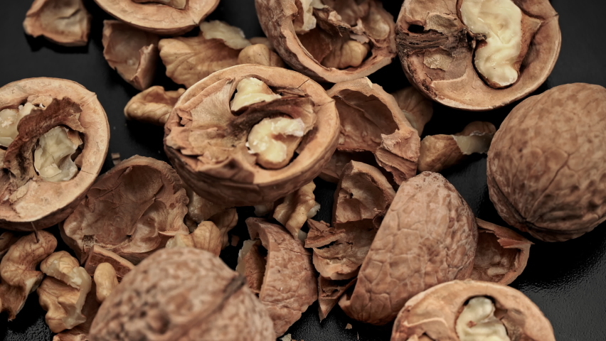 Lot of walnuts in the shell are spinning on a black background. Nuts are good for the brain. Heap of walnuts close-up. | Shutterstock HD Video #1092117077