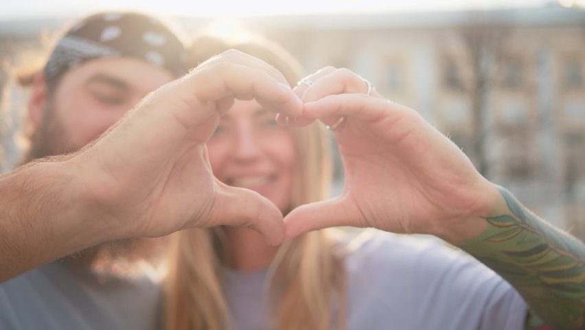Heart valentine day Beauty Close up portrait happy family couple making heart gesture with fingers, hipster man tattoo woman showing love hands, demonstrating sincere feelings together indoors in city | Shutterstock HD Video #1092120041