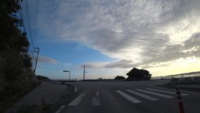 OKINAWA, JAPAN - AUGUST 2021 : Driving shot of Okinawa in sunset time. Point of view (POV), seaside road drive, time lapse shot. Summer holiday, vacation and travel concept video.