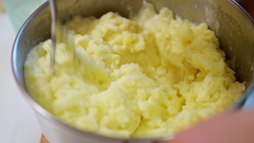 Female hands with a pusher knead boiled potatoes, mashed potatoes | Shutterstock HD Video #1092126145