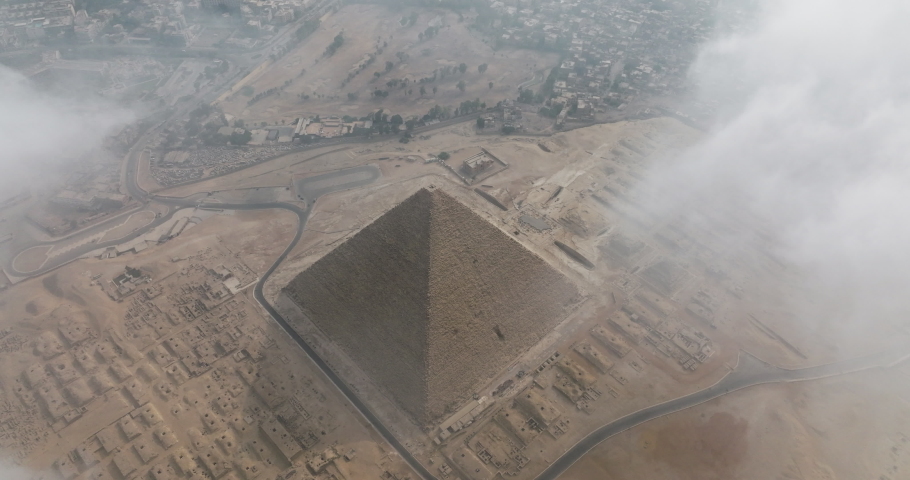Aerial shot of Egyptian Pyramids in Giza under moving Clouds. Giza Pyramids under clouds