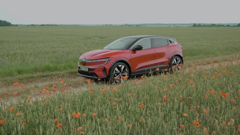 Riga, Latvia 11 July 2022, Renault Megane E-Tech Electric is a battery electric-powered small family car. Stands on road at background landscape puppy field countryside mood.