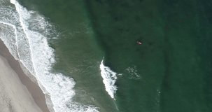 Aerial view of surfers and blue barrel wave in ocean. Surfing and waves. Sea Water and Surfers Aerial View