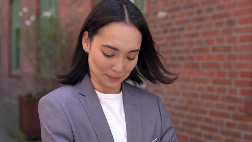 Confident proud young adult Asian business woman professional leader, corporate manager, businesswoman entrepreneur wearing suit looking at camera standing arms crossed outside office, portrait. Royalty-Free Stock Footage #1092140689