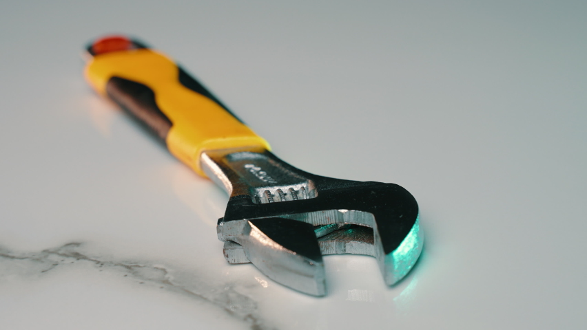 Adjustable wrench for screwing and unscrewing bolts and pipes of different diameters. Plumbing small wrench with adjustable hole diameter. Metal industrial device for repair. Camera rotation