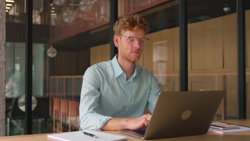 Young professional business man, freelancer, focused ethnic successful ceo, wearing glasses working on laptop, and studying using computer for online seminar webinar at office, coworking, library.