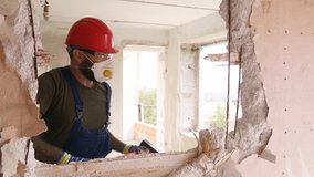 Contractor wrecks wall with sledgehammer making hole for rearrangement. Man doing manual dismantling and demolition works with big hammer hits for apartment renovation. Construction worker in uniform. - Powered by Shutterstock - Get 15% off with code: PIKWIZARD15