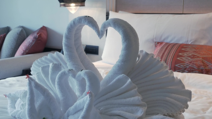 Toallas de cisne en la cama en una habitación de hotel