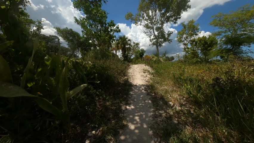 First-person point-of-view twisting, banking and weaving up an advanced bike trail hilltop overlooking a lake in a hot sunny afternoon in July at Quiet Waters Park, Deerfield Beach, Florida