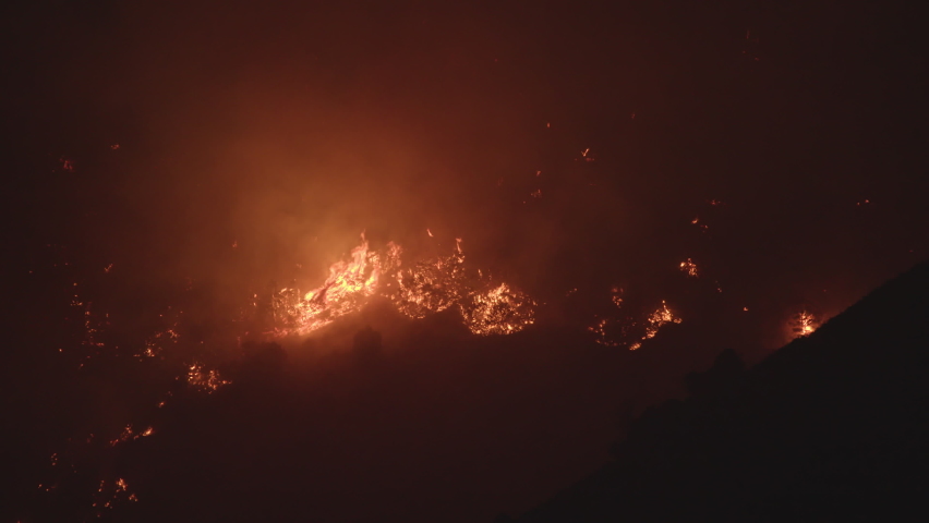 Wildfire burning on mountain side that was human caused in Utah as it works its way through the brush.