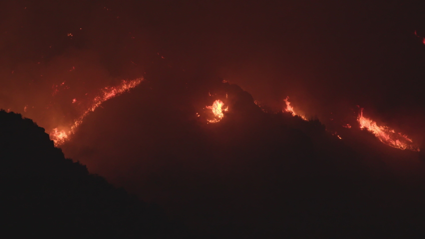 Mountain side burning from wildfire caused by irresponsible humans not being safe during the hot dry summer season in Utah.
