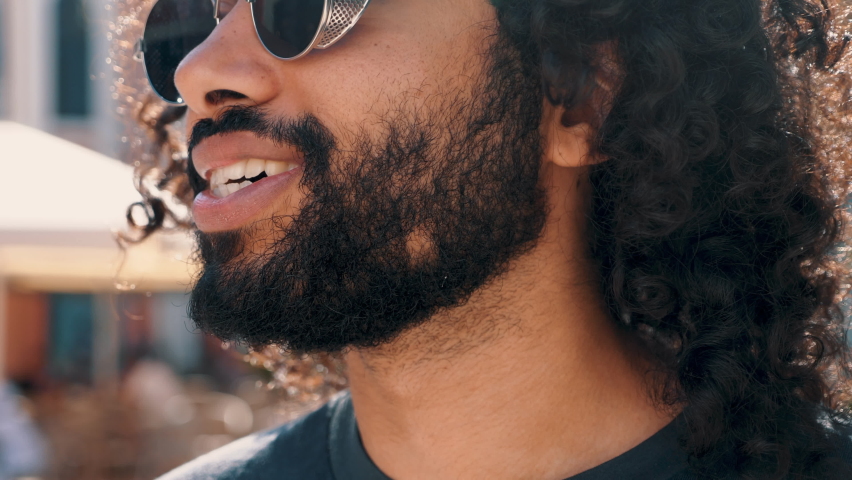 Closeup portrait of handsome smiling hipster model.Unshaven Arabian man smoking electronic cigarette. Fashion male with long curly hairstyle posing in the street. Makes smoke. Steam from vape Royalty-Free Stock Footage #1092158511
