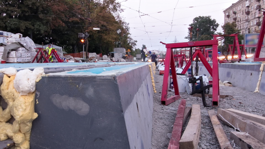 Tram rails at the stage of their installation and integration into concrete plates on the road day to night timelapse hyperlapse. Filling by liquid resin for reduction of vibration and noice. The