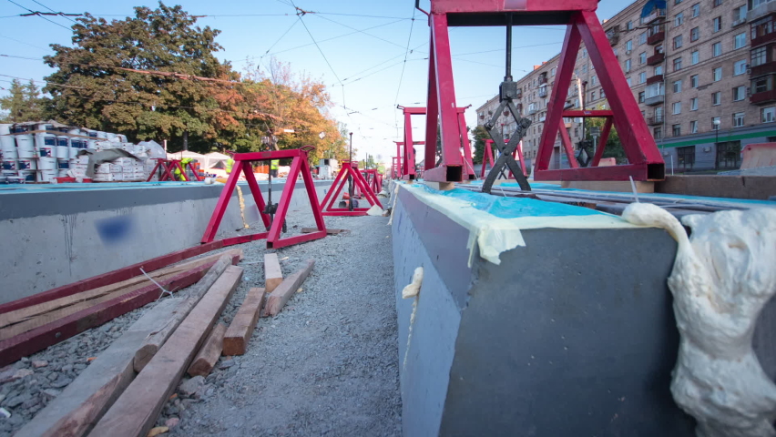 Tram rails at the stage of their installation and integration into concrete plates on the road timelapse hyperlapse. Filling by liquid resin for reduction of vibration and noice. The process of