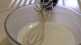 After whisking or scrambling egg and sugar, mixture at blender is dribbling. Close up dripping mixture. Food satisfaction videos. 