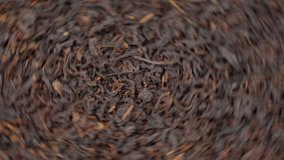 Dry black tea leaves close up. Dark background. Food and drink cooking video.