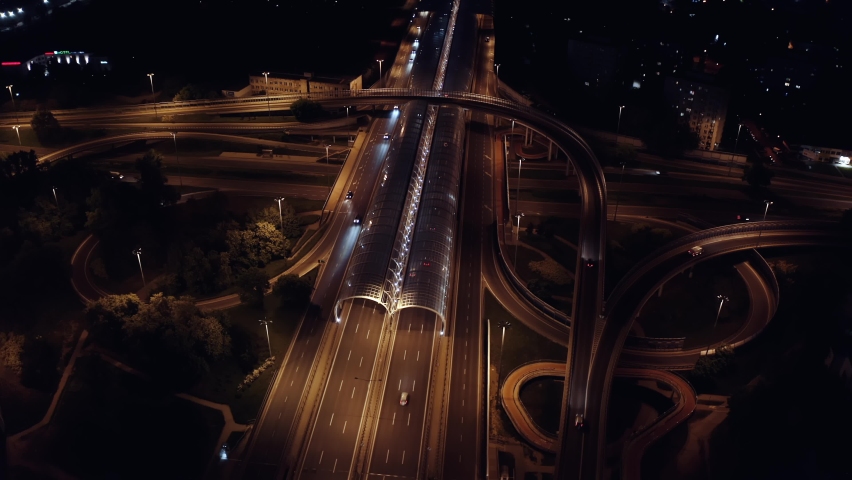 Aerial elevated multiple roads junction. Drone footage modern city highway road junctions in evening. Intersection freeway road overpass. Lot of cars driving busy highway. Night shot, dusk Royalty-Free Stock Footage #1092173231
