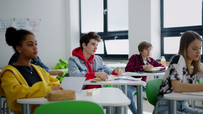 High school students paying attention in class, sitting in their desks and raising hand. Royalty-Free Stock Footage #1092175407