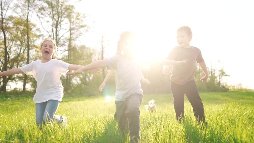 group of children running in the park. happy family baby kid dream concept. kindergarten. children hands to the sides play pilots plane run on the sun grass in the summer in the park Royalty-Free Stock Footage #1092182223