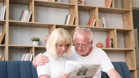 European retired couple reading the latest newspaper, they are hugging while sitting on the sofa  - Powered by Shutterstock - Get 15% off with code: PIKWIZARD15