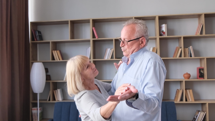 Happy active senior couple dancing at home together, cheerful carefree old mature man and woman Royalty-Free Stock Footage #1092187457